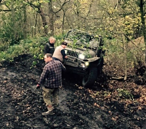 Participants beside an off-road vehicle on a woodland activity day