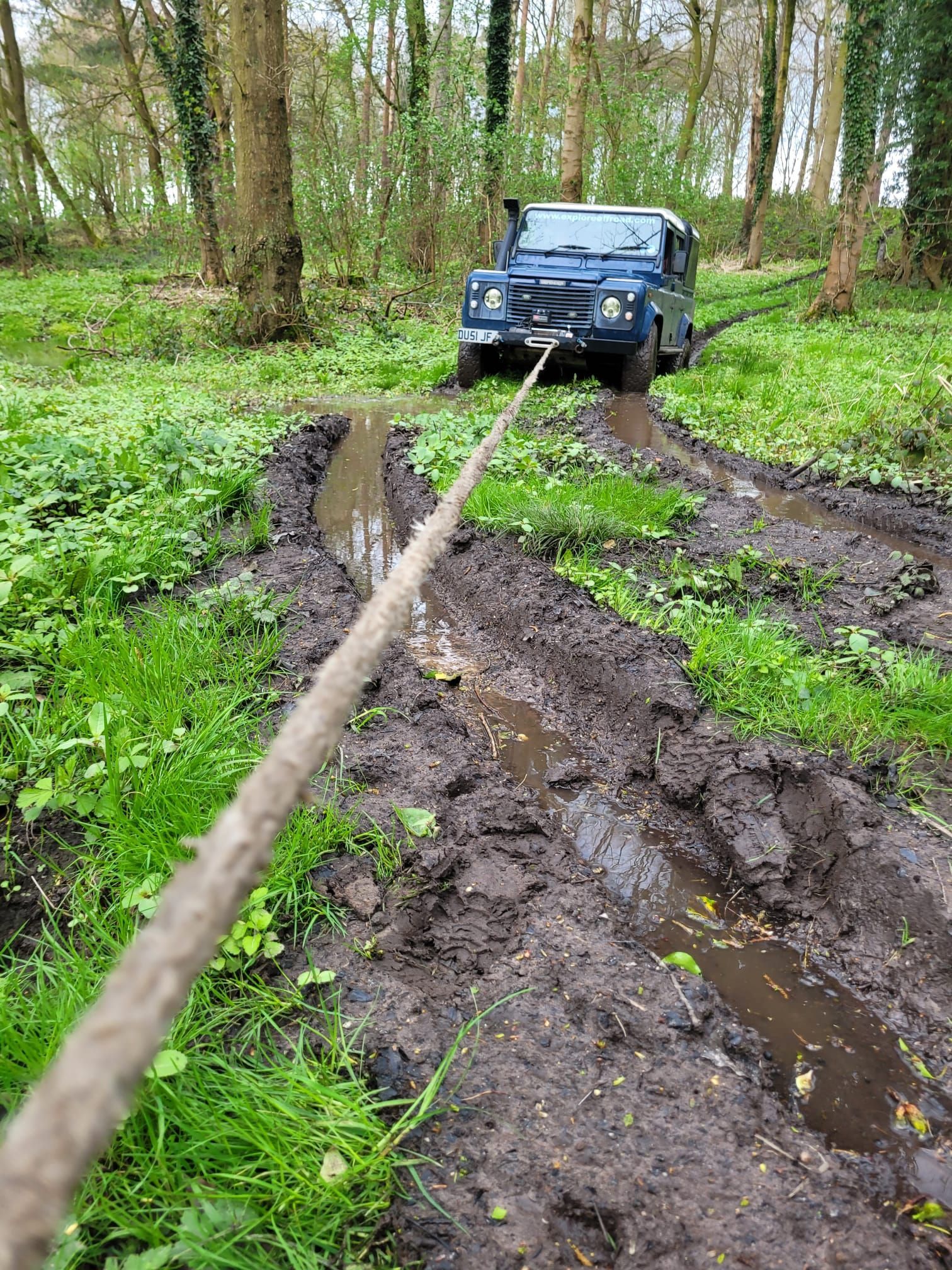 Blue Defender on a deeply rutted, muddy woodland track